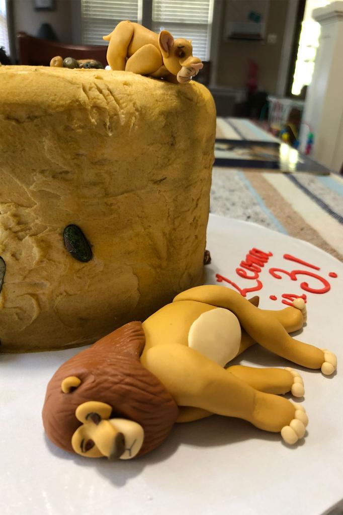 The birthday cake shows Mufasa lying dead while Simba looks from above.