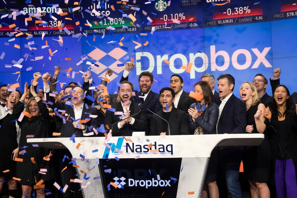 Confetti showered Dropbox CEO Drew Houston and Dropbox co-founder Arash Ferdowsi (center) as they celebrated the launch of Dropbox's initial public offering in March 2018, ringing the opening bell at the Nasdaq.