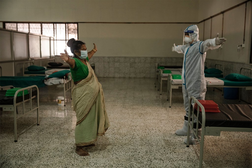 A therapist teaches a breathing exercise to a COVID-19 patient at the Radhaswami Isolation center in Kathmandu, Nepal on May 25, 2021.