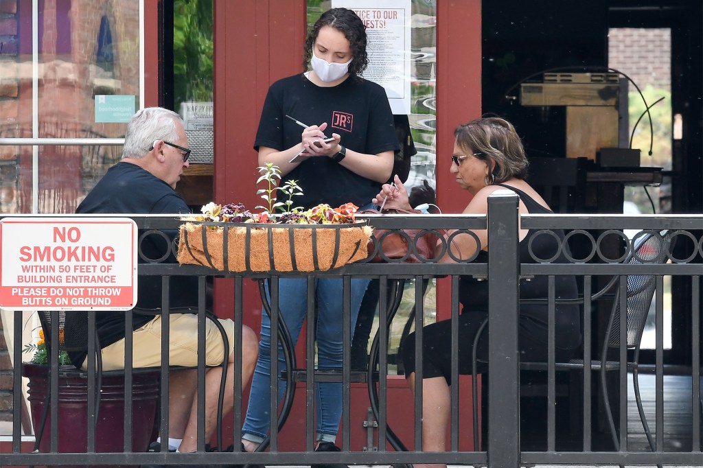 Restaurant staff practices social distancing while waiting on customers seated on the patio at Junior's Bar & Grill  in Madison Avenue Thursday June 4, 2020.