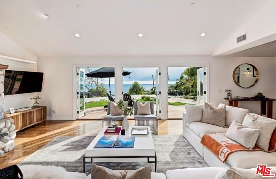 The indoor-outdoor living room has pocket doors.