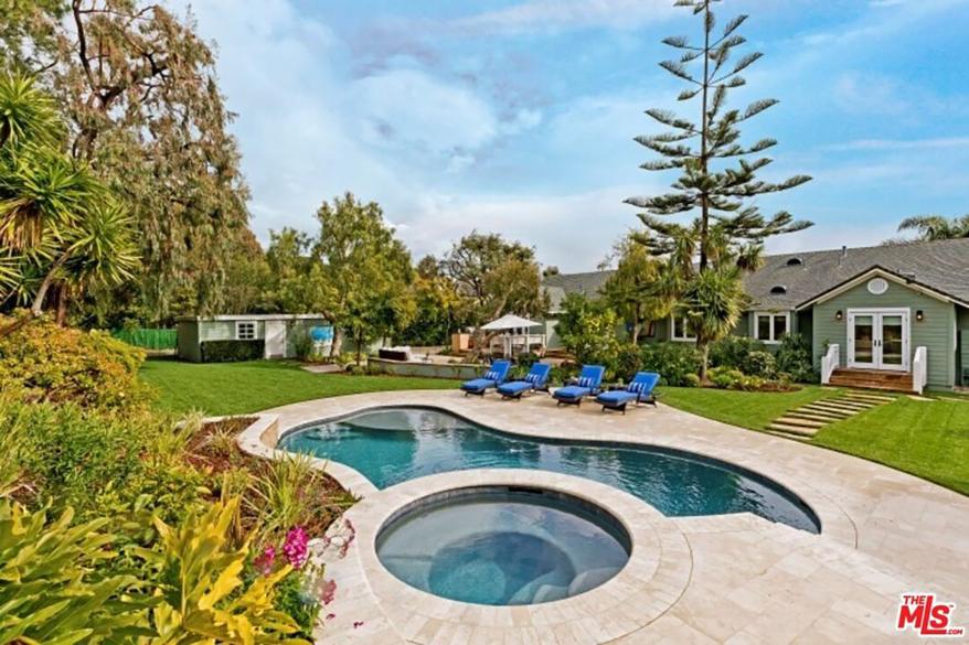 The 0.7-acre lot has stone patio, built-in barbecue and a pool with a Baja shelf and a hot tub, according to the listing.