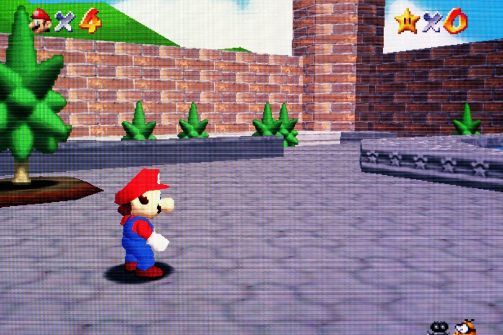 A screenshot of the game shows Mario exploring the courtyard of Princess Peach's castle in full 3D -- which was a watershed moment in video game history.