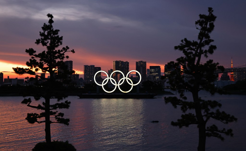 A barge carrying the Olympic Rings crosses Tokyo Bay.