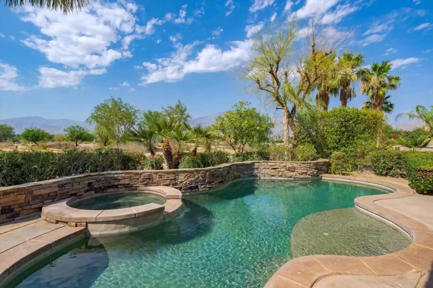 The irregularly-shaped pool with a hot tub is lagoon-inspired.