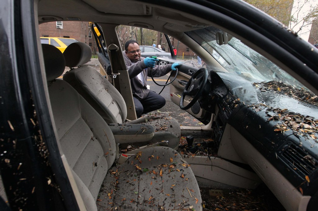 A man cleaning his car in Manhattan after it was flooded by Hurricane Sandy.