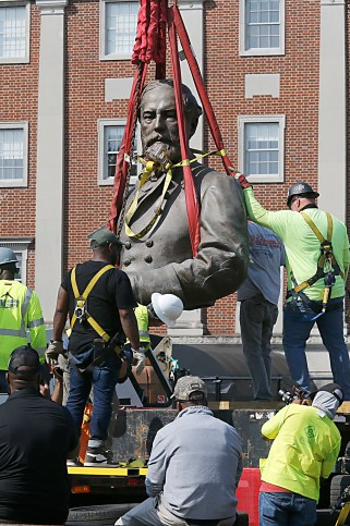 Workers remove the top half of Confederate General Robert E. Lee’s statue on Monument Avenue in Richmond, Virginia on September 8, 2021.