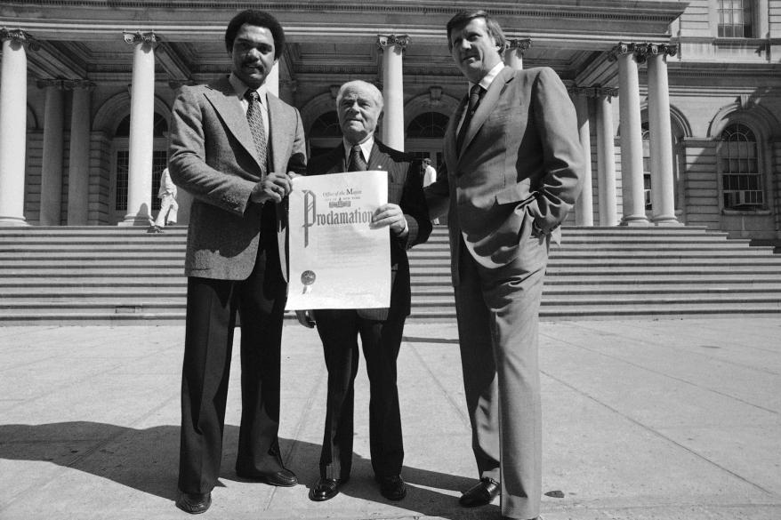 New York Yankee slugger Reggie Jackson, right, holds proclamation which New York Mayor Abe Beame, center, has just presented to Yankees owner George M. Steinbrenner, Wednesday, Sept. 28, 1977 at City Hall in New York.