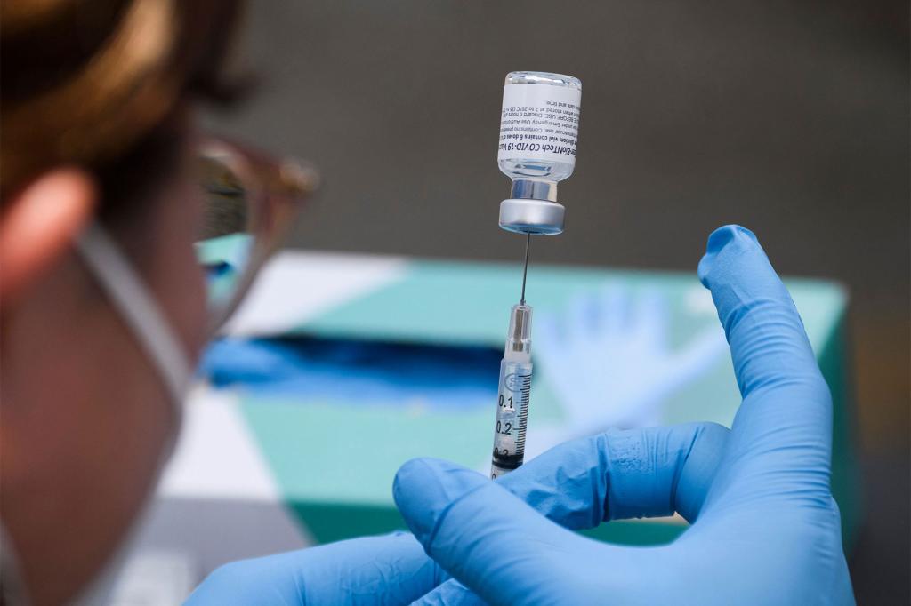 A syringe is filled with a first dose of the Pfizer Covid-19 vaccine at a mobile vaccination clinic during a back to school event offering school supplies, Covid-19 vaccinations