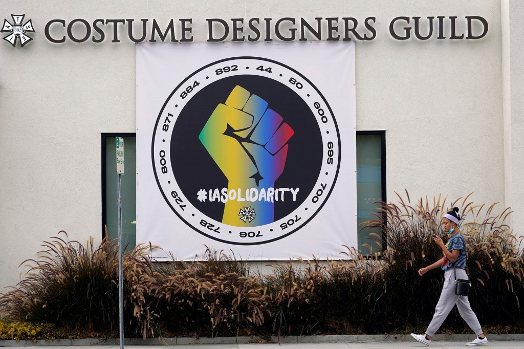 A poster advocating union solidarity in front of a Costume Designers Guild office building.