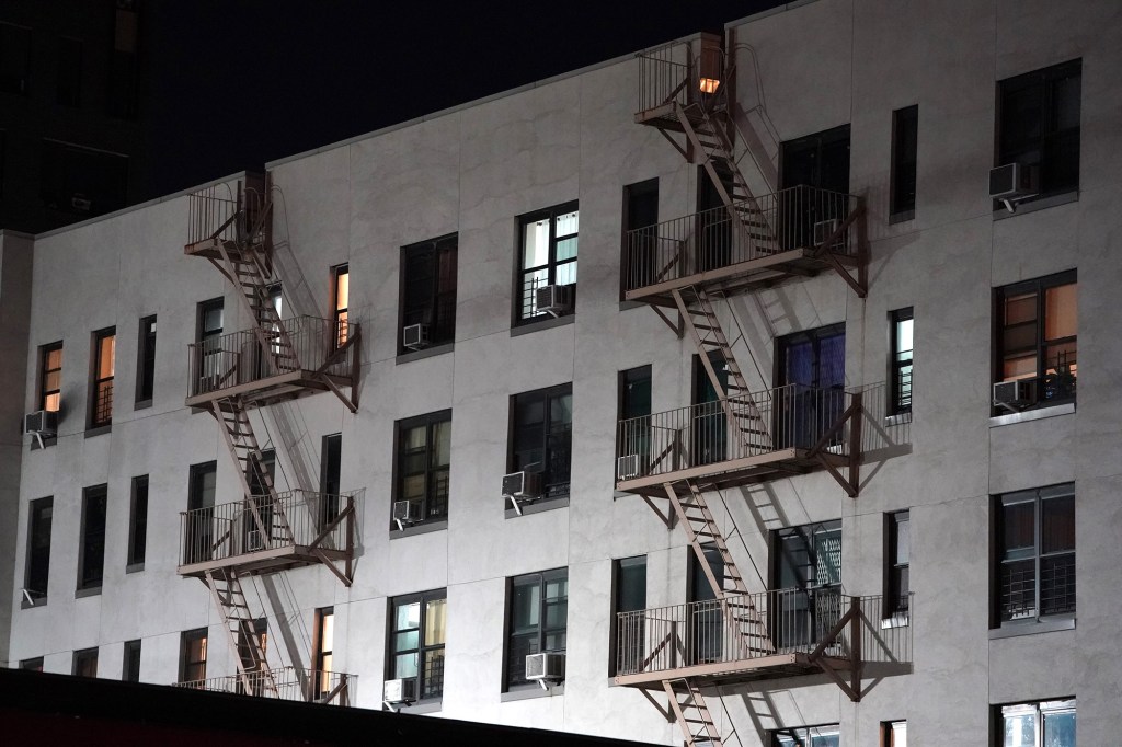 general view of an apartment building with an external fire escape as seen at night in the Bronx, NY