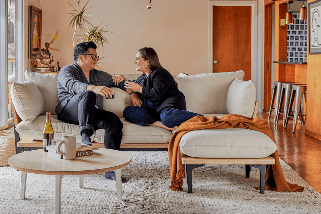 A couple on a beige couch in a living room 