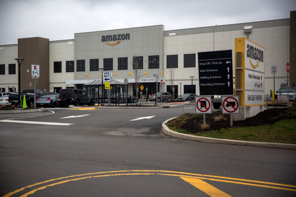 Vehicles sit parked outside an Amazon.com Inc. warehouse.