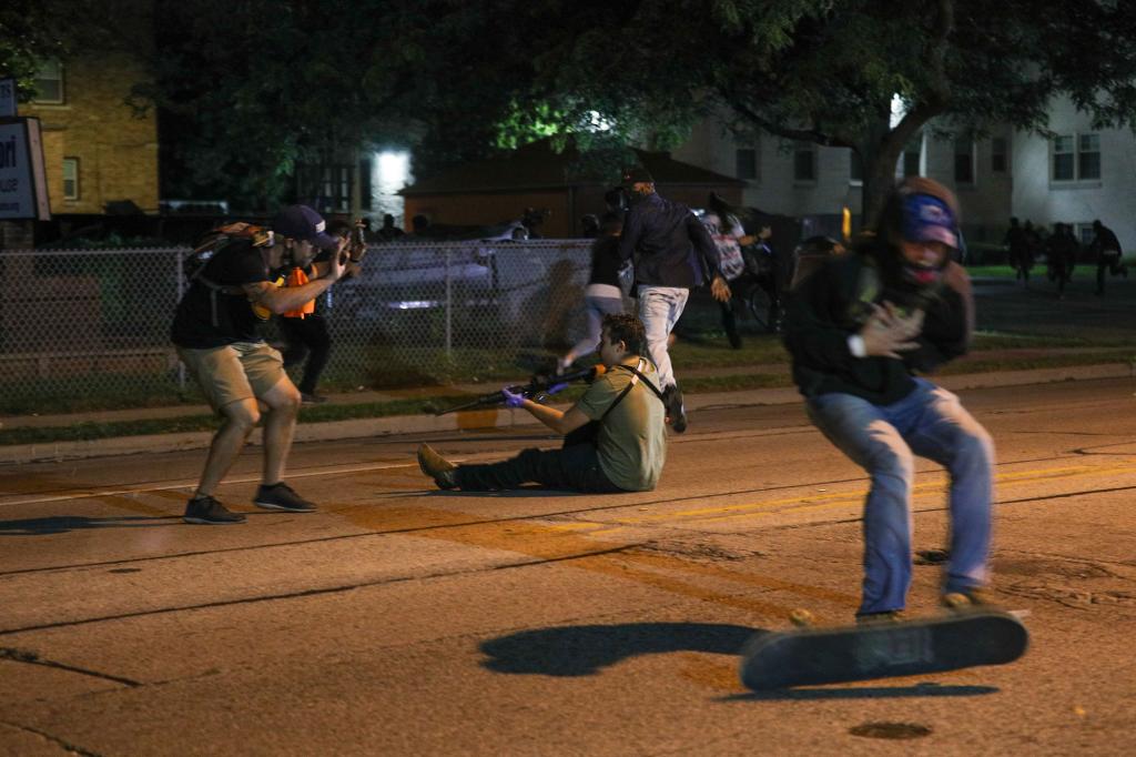 A man (right) was allegedly shot in the chest by Kyle Rittenhouse (center) as protesters and armed civilians clashed on the streets of Kenosha.