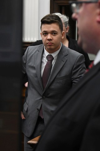 Kyle Rittenhouse (left) looks at a video screen as attorneys for both sides argue about a video in Rittenhouse's trial.