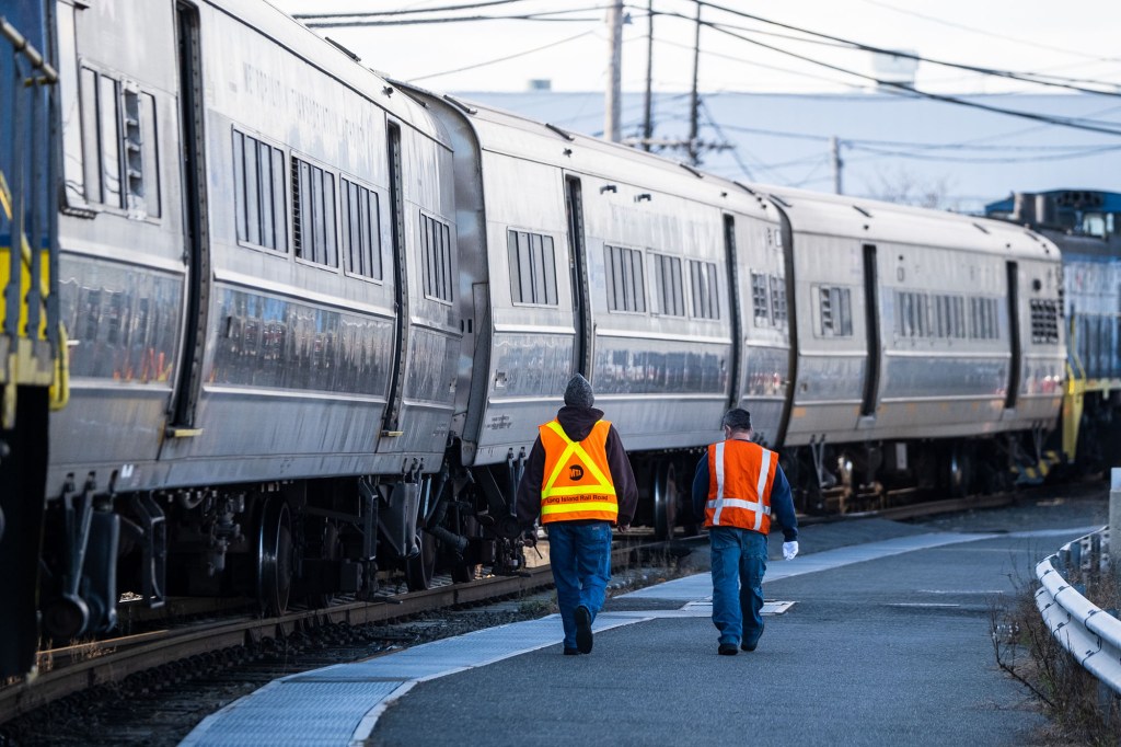 MTA workers next to LIRR train