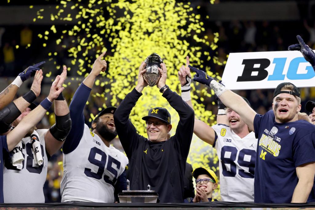 Michigan head coach Jim Harbaugh celebrates with the trophy after the Wolverines won the Big Ten Championship game at Lucas Oil Stadium on Dec. 4, 2021 in Indianapolis, Indiana.