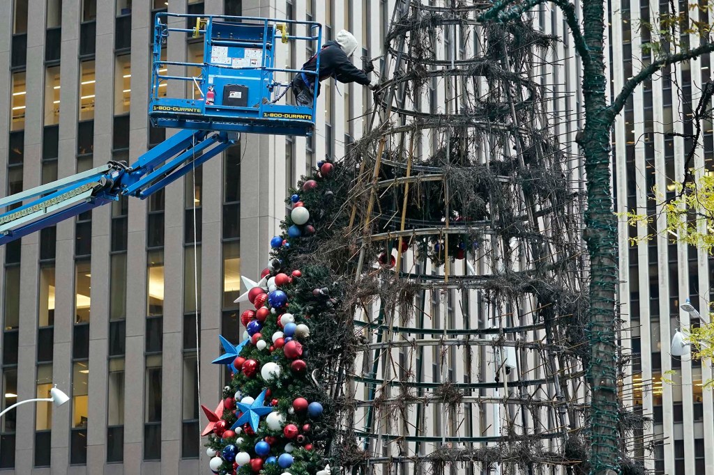 A worker disassembles the damaged tree after Wednesday's arson attack.