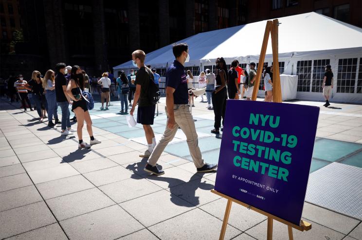 People wear protective masks as they wait in line at a testing site for the coronavirus disease (COVID-19) set up for returning students, faculty and staff on the main campus of New York University (NYU)