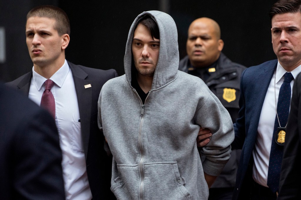 Martin Shkreli in handcuffs being led away by law enforcement officers