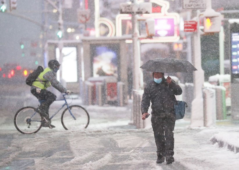 Pedestrians walk through Times Square during a snow storm in New York City on Jan. 7, 2022.