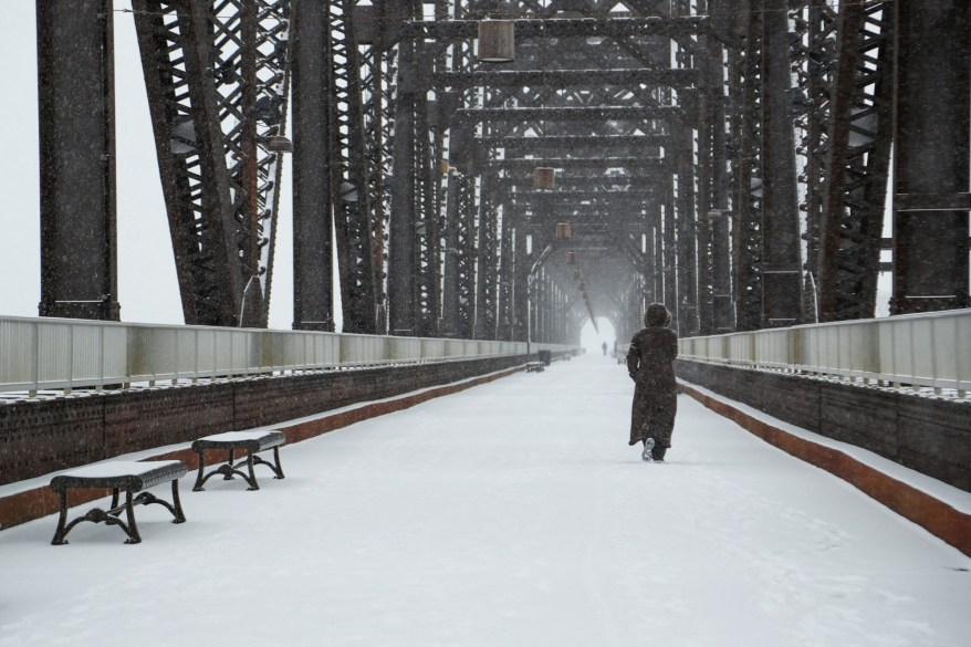 A woman walks on the Big Four Bridge during a snow storm in Louisville, Kentucky on January 6, 2022.