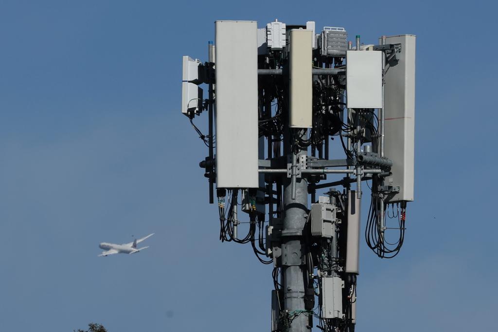 A United Airlines plane flies by a cellular tower as it takes off from San Francisco International Airport on January 18.