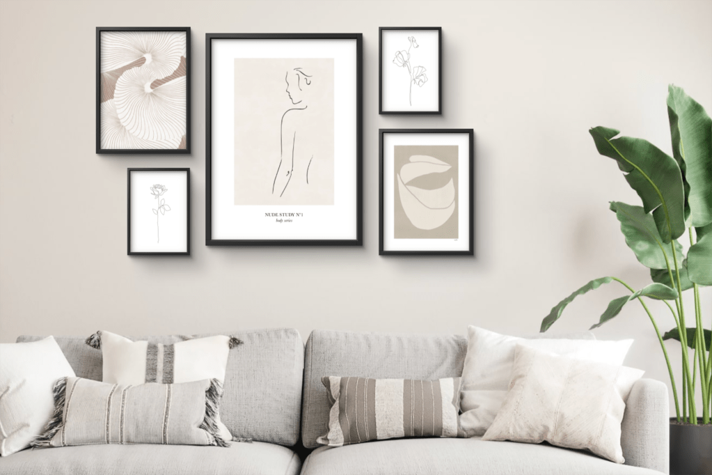 An array if five pictures framed on a gray wall above a gray couch 