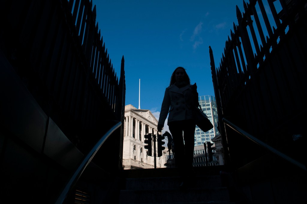 A businesswoman in shadow walks down stairs