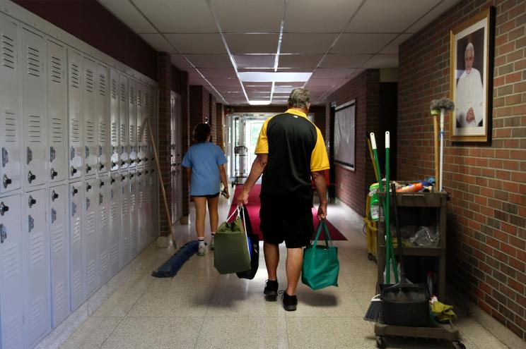 Cesa Pusateri, 12, and her grandfather, Timothy Waxenfelter, principal of Quigley Catholic High School, leave with his collection of speech and debate books after the recent closure of the school in Baden, Pa., Monday, June 8, 2020.