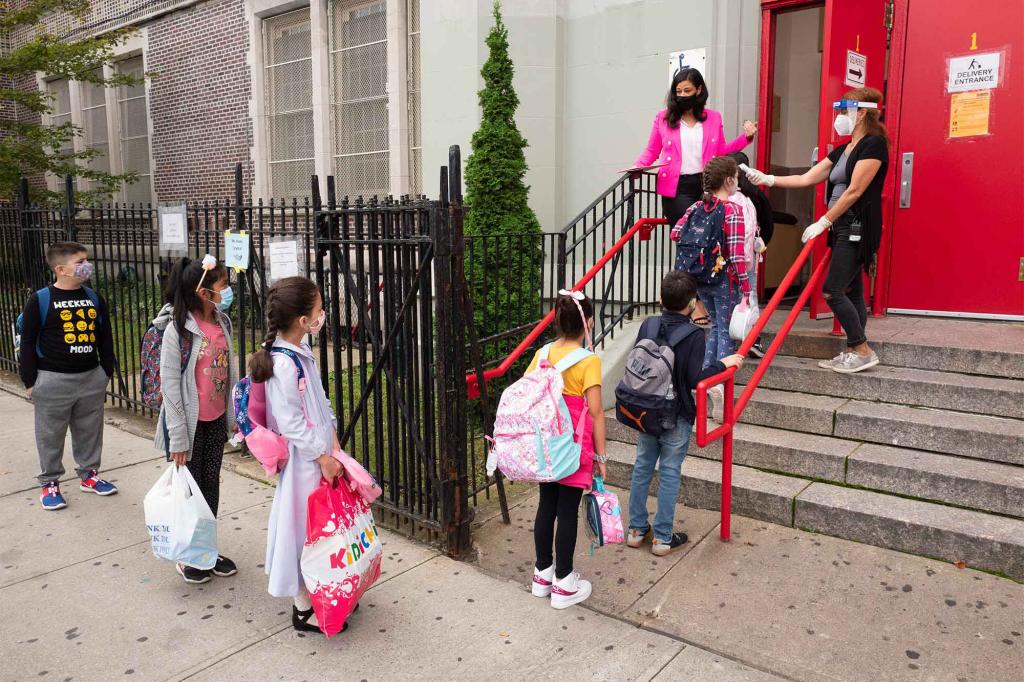 Students line up to have their temperature checked before entering PS 179 elementary school in Brooklyn.