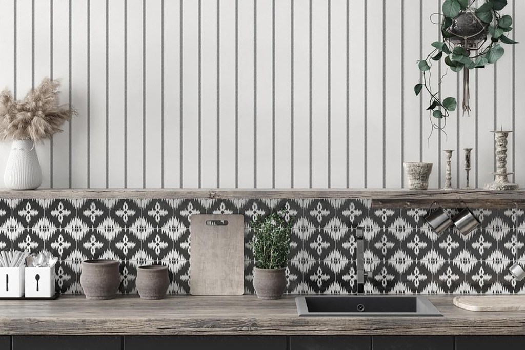 A kitchen with stripped wallpaper and a patterned backsplash 