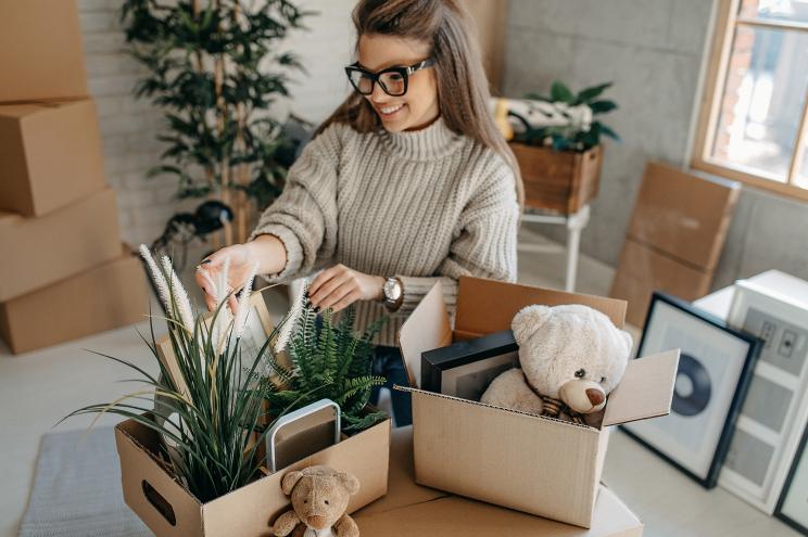 A woman in an apartment unpacking boxes