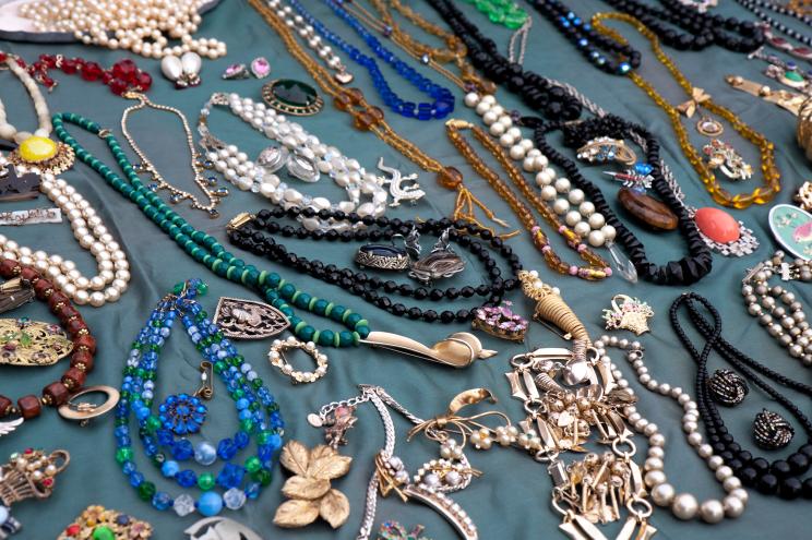 Old costume jewelry on a stall in a London flea market on a blue background.