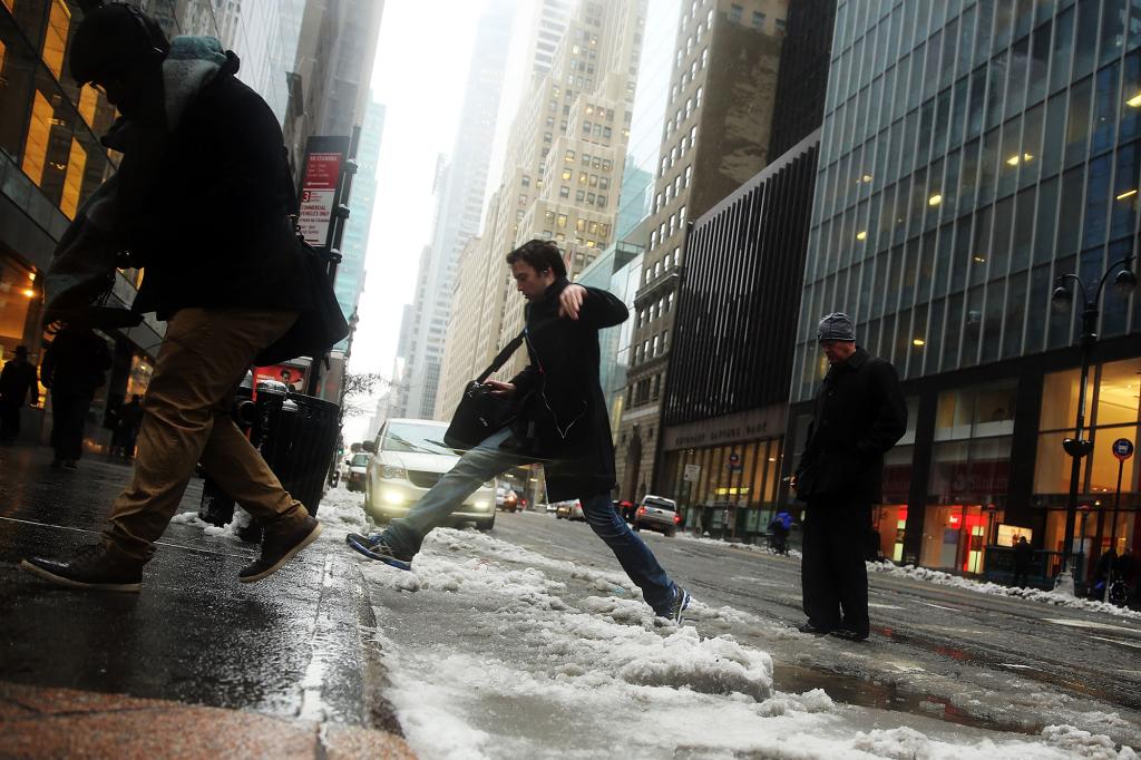 Pedestrians navigate the snow, ice and puddles along Manhattan's streets.