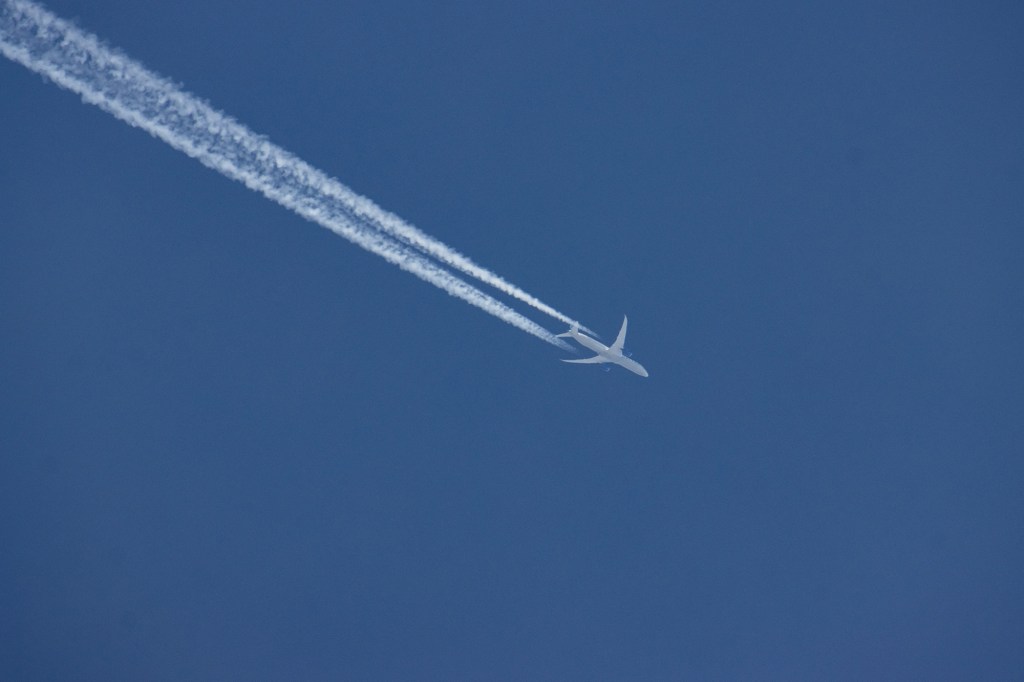 A United Airlines Boeing 787 Dreamliner airplane is seen overflying in the blue sky over Amsterdam.