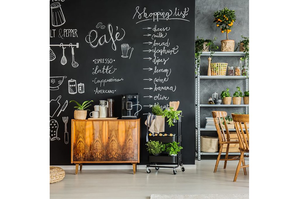 A kitchen with a blackboard wall and writing on it 