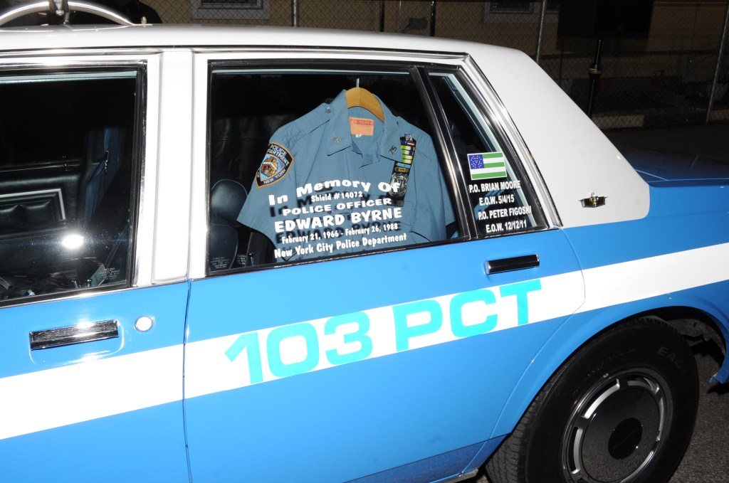 A police car to remember Edward Byrne is seen with his uniform inside the vehicle on the corner of 107th Ave. and Inwood St. in South Jamaica.