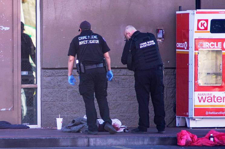 Albuquerque Police crime scene specialists photograph bloody articles of clothing.