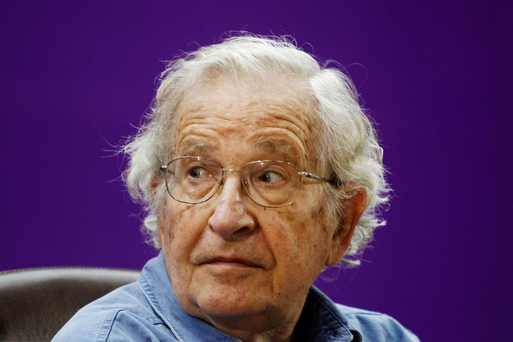 Picture of Noam Chomsky wearing glasses against a purple background