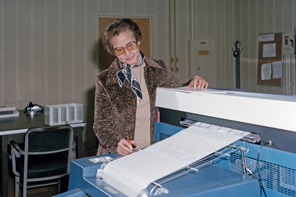 NASA scientist Katherine Johnson in front of mathematical machinery