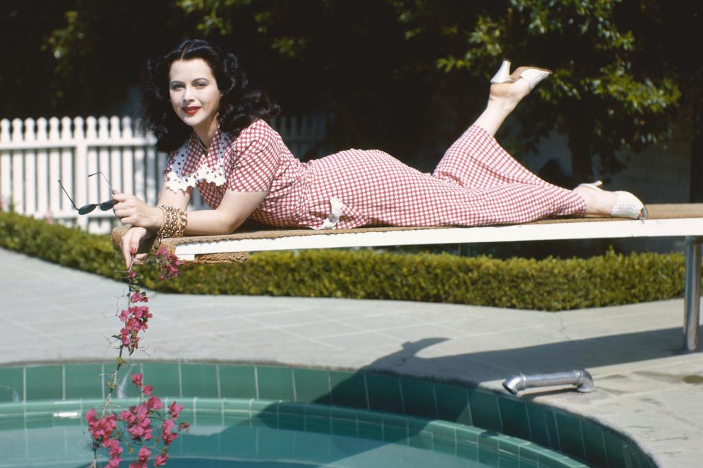 Hedy Lamarr poses in a gingham dress on a diving board