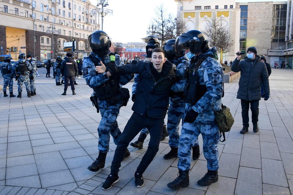 Police officers detaining a man in Moscow for protesting the Ukraine war on February 27, 2022.