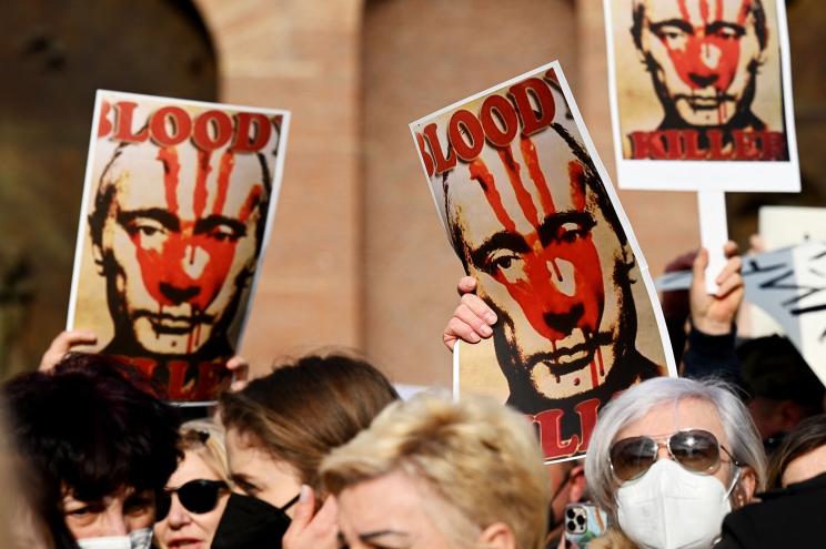 Protesters hold placards of Russia's President Vladimir Putin as they attend a demonstration in support of Ukraine.