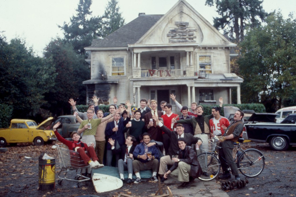 van Reitman (bottom center) posing in front of the Delta Tau Chi Frat house with cast members, from left: Joshua Daniel, Douglas Kenney, Tom Hulce, John Belushi, Peter Riegert, James Widdoes, Tim Matheson, Stephen Furst, Chris Miller, Bruce Bonnheim, Bruce McGill