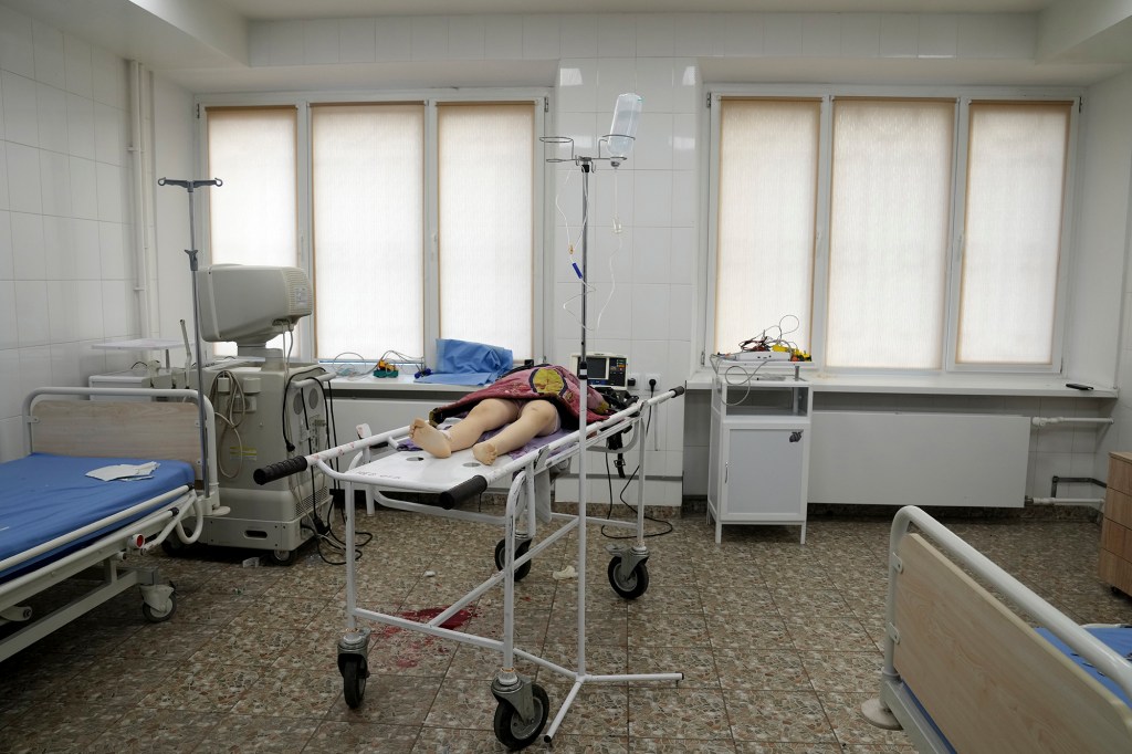 The lifeless body of a girl killed during the shelling of a residential area lies on a medical cart at the city hospital of Mariupol, eastern Ukraine.