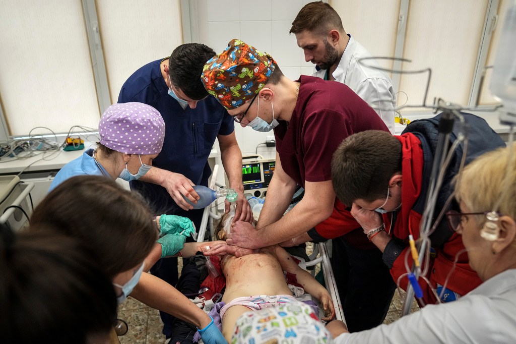 Medics perform CPR on a girl.