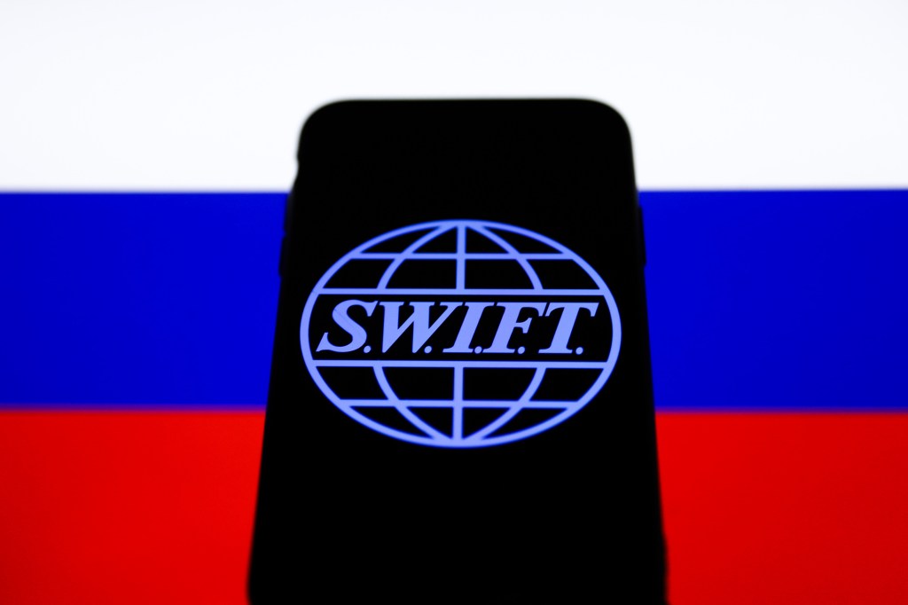 Photo illustration of SWIFT and Russian flag