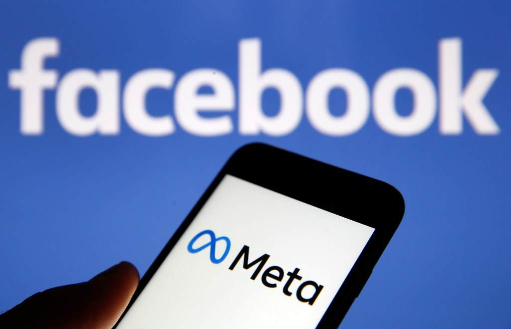 In this photo illustration, the Meta logo is displayed on the screen of an iPhone in front of a Facebook logo