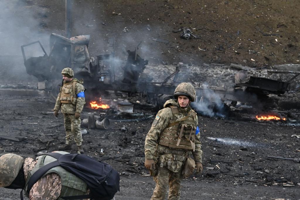 Ukrainian service members look for and collect unexploded shells after a fighting with Russian raiding group.